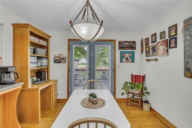 203 Pine St, Wellsville, KS 66092 - dining space featuring french doors, light wood-type flooring, and baseboards