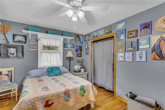 203 Pine St, Wellsville, KS 66092 - bedroom featuring wood finished floors, a closet, a ceiling fan, and baseboards