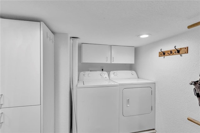 203 Pine St, Wellsville, KS 66092 - laundry area featuring cabinet space, independent washer and dryer, a textured ceiling, and a textured wall
