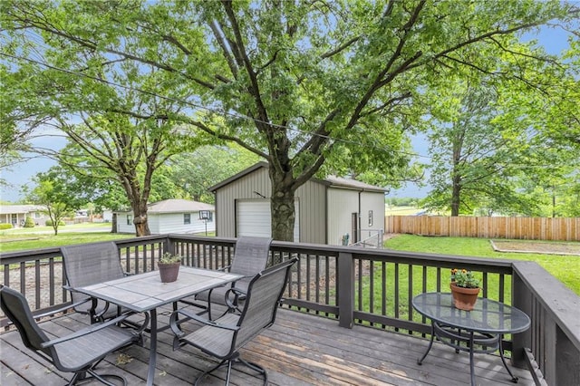 203 Pine St, Wellsville, KS 66092 - wooden terrace featuring outdoor dining area, an outdoor structure, and a detached garage