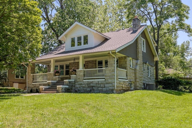 view of front of property featuring stone siding, a porch, a chimney, central AC unit, and a front yard