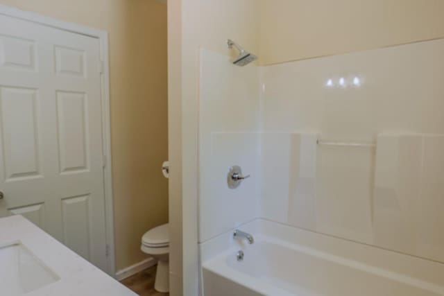full bathroom featuring toilet,  shower combination, and a sink
