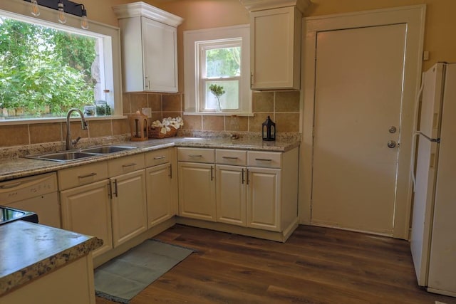 kitchen featuring a sink, freestanding refrigerator, dark wood finished floors, decorative backsplash, and white cabinets