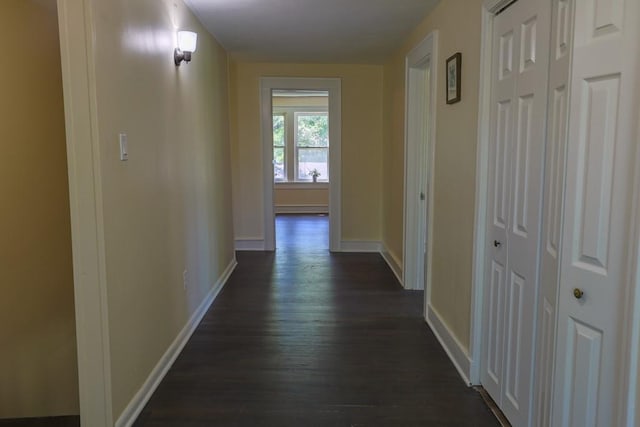 hall featuring dark wood-style floors and baseboards