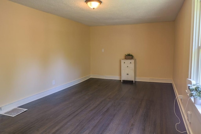 1515 E 77th Ter, Kansas City, MO 64131 - unfurnished room with dark wood-style flooring, a textured ceiling, and baseboards