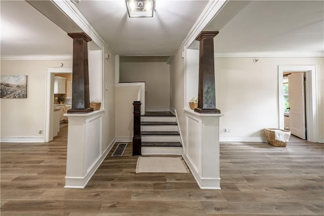 1515 E 77th Ter, Kansas City, MO 64131 - stairs featuring decorative columns, crown molding, and wood finished floors