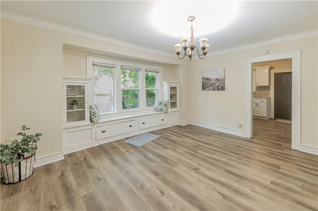 1515 E 77th Ter, Kansas City, MO 64131 - unfurnished dining area featuring a chandelier, crown molding, and light wood finished floors