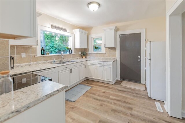 1515 E 77th Ter, Kansas City, MO 64131 - kitchen with white appliances, white cabinetry, backsplash, light wood-style floors, and light stone counters
