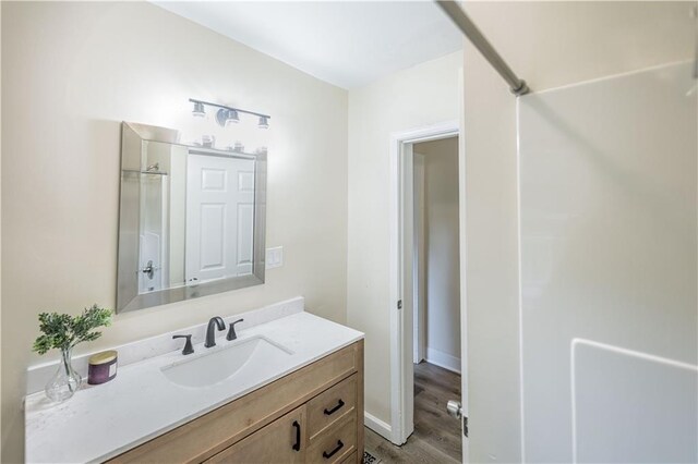 1515 E 77th Ter, Kansas City, MO 64131 - bathroom with vanity, wood finished floors, and a shower