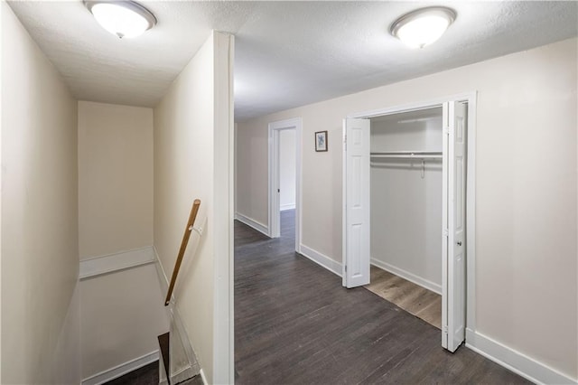 1515 E 77th Ter, Kansas City, MO 64131 - hallway featuring an upstairs landing, dark wood-type flooring, and a textured ceiling