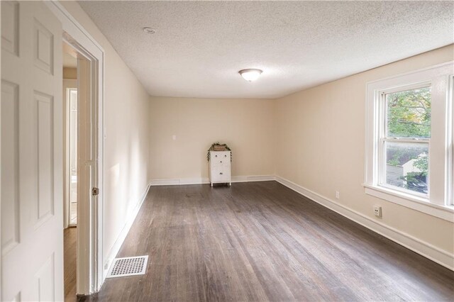 1515 E 77th Ter, Kansas City, MO 64131 - empty room with dark wood-style flooring and a textured ceiling