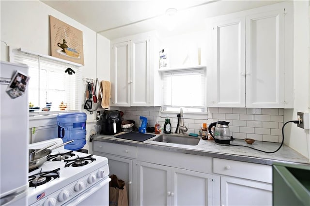 kitchen with gas range gas stove, a sink, refrigerator, and white cabinets