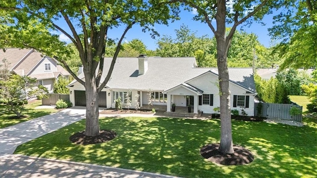view of front of property featuring concrete driveway, a chimney, and a garage