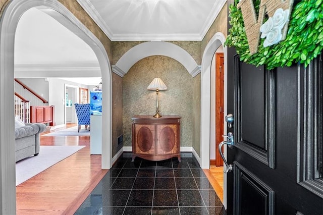 foyer entrance with granite floors, arched walkways, crown molding, baseboards, and stairs