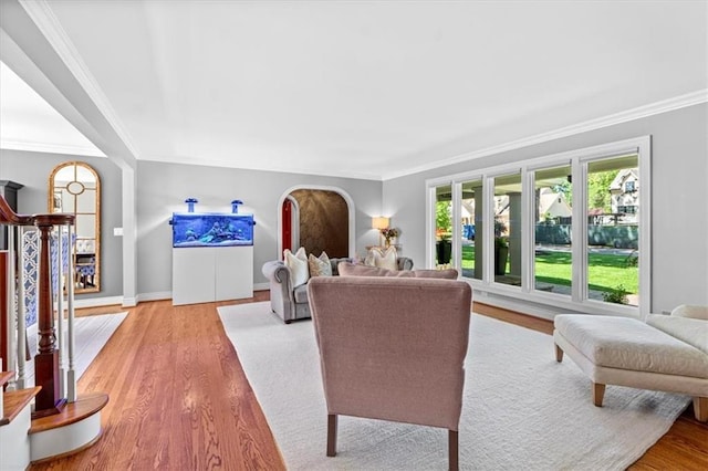 living room with crown molding, wood finished floors, and baseboards