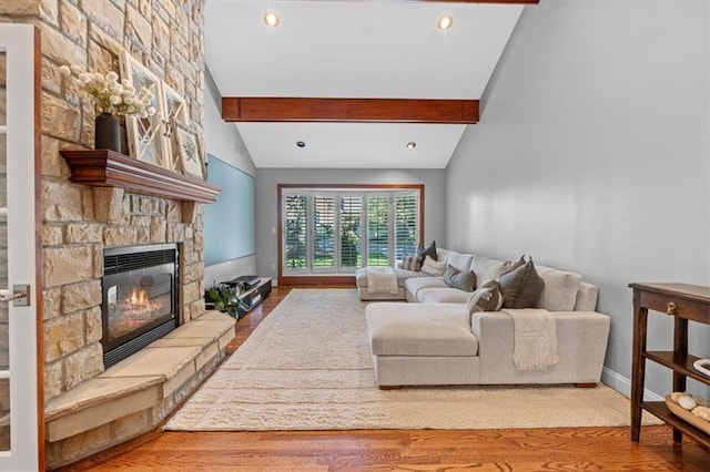 living room featuring wood finished floors, a stone fireplace, recessed lighting, and baseboards