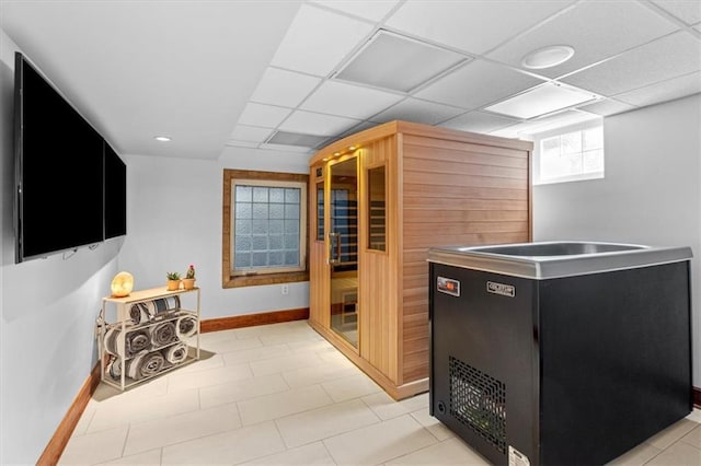 kitchen featuring dark cabinets, baseboards, and a drop ceiling