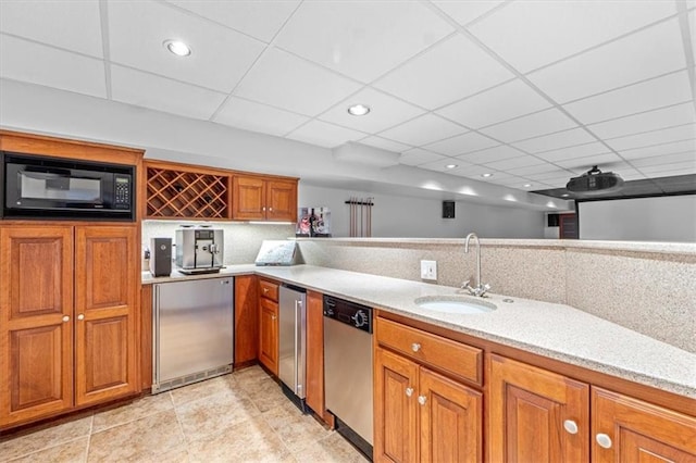 kitchen featuring fridge, a sink, stainless steel dishwasher, black microwave, and brown cabinets