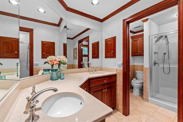 bathroom with a stall shower, wainscoting, toilet, tile walls, and crown molding