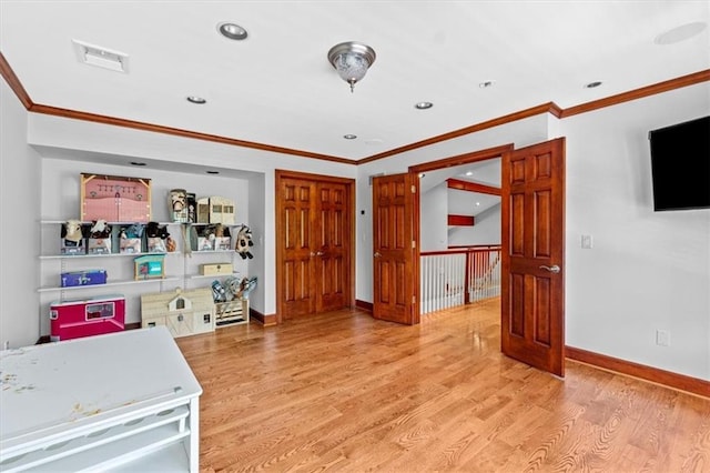 interior space featuring wood finished floors, ornamental molding, baseboards, and recessed lighting