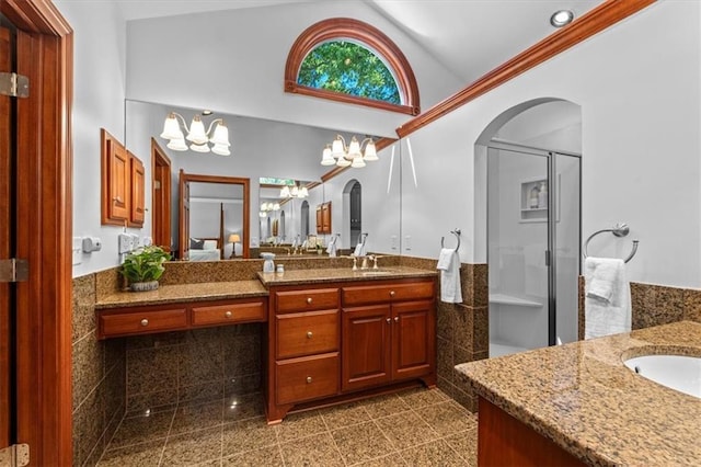 bathroom with a chandelier, vaulted ceiling, vanity, a shower stall, and granite floors