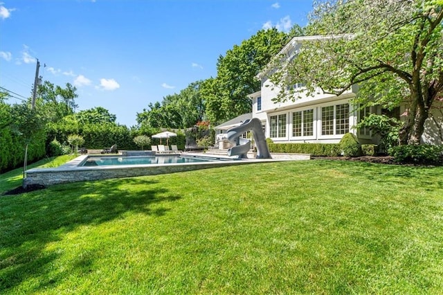 back of house featuring a lawn and an outdoor pool