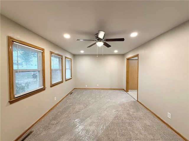 empty room featuring light carpet, baseboards, a ceiling fan, and recessed lighting