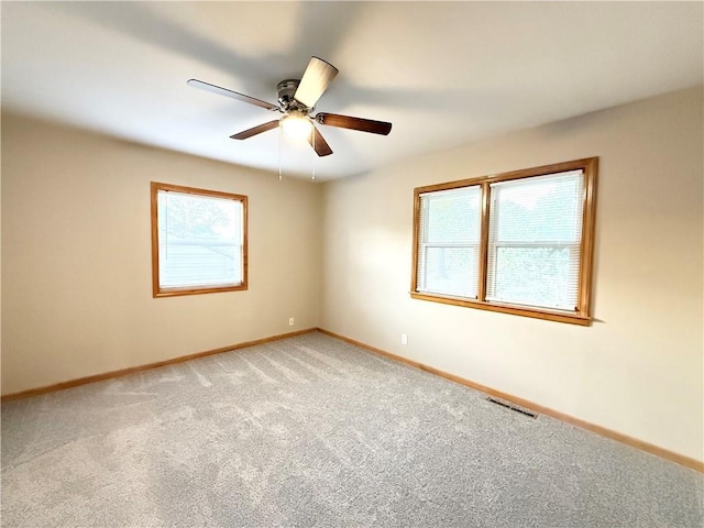 empty room featuring carpet, baseboards, and ceiling fan