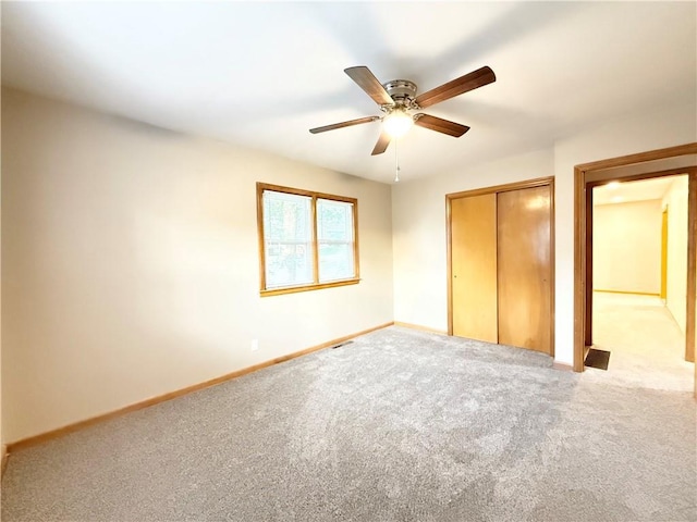 unfurnished bedroom featuring a closet, carpet, baseboards, and a ceiling fan