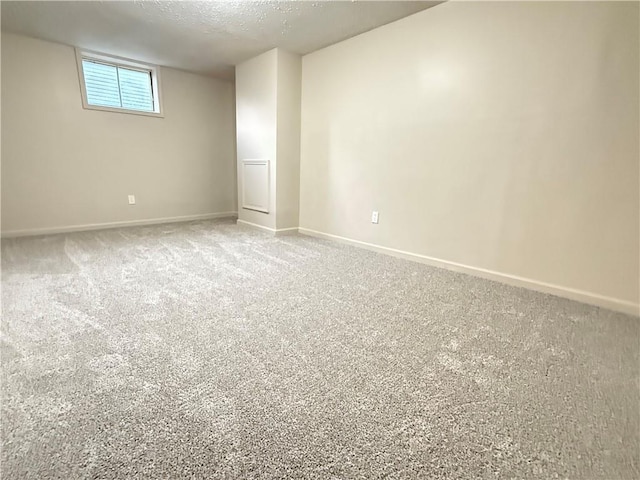 carpeted spare room with baseboards and a textured ceiling