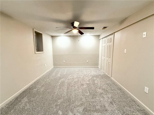 unfurnished bedroom with carpet flooring, baseboards, ceiling fan, and a closet