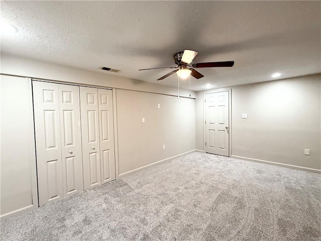 unfurnished bedroom featuring carpet, baseboards, a textured ceiling, a ceiling fan, and a closet