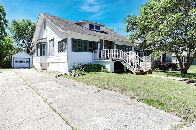 827 Pacific Ave, Osawatomie, KS 66064 - bungalow-style house featuring an outdoor structure, a detached garage, a front yard, driveway, and roof with shingles