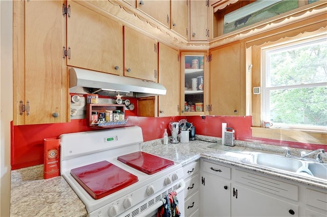 827 Pacific Ave, Osawatomie, KS 66064 - kitchen with white gas range oven, under cabinet range hood, light countertops, a sink, and glass insert cabinets