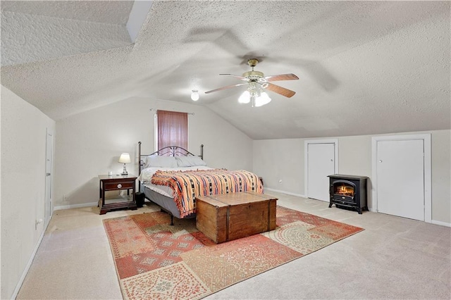 827 Pacific Ave, Osawatomie, KS 66064 - bedroom with a textured ceiling, carpet floors, a wood stove, lofted ceiling, and baseboards