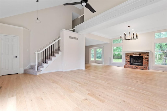 1051 E 121st St, Olathe, KS 66061 - unfurnished living room featuring a chandelier, plenty of natural light, wood finished floors, stairs, and a high ceiling