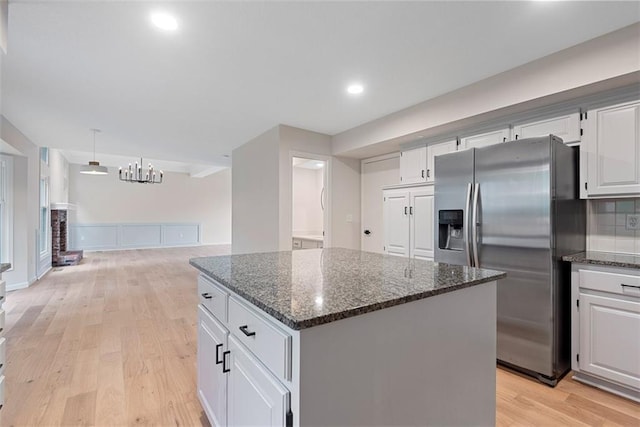 1051 E 121st St, Olathe, KS 66061 - kitchen featuring stainless steel refrigerator with ice dispenser, a center island, light wood-style flooring, dark stone countertops, and white cabinetry