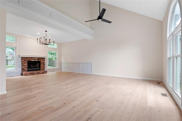 1051 E 121st St, Olathe, KS 66061 - unfurnished living room featuring a chandelier, light wood finished floors, healthy amount of natural light, ceiling fan, and high vaulted ceiling
