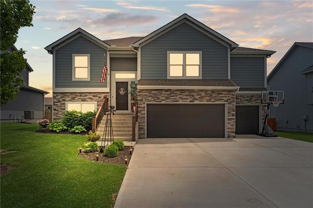 16025 Craig St, Basehor, KS 66007 - view of front of home with an attached garage, a lawn, concrete driveway, stone siding, and central AC unit