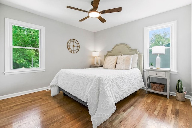 9811 Cambridge Ave, Kansas City, MO 64134 - bedroom with multiple windows, wood finished floors, and baseboards
