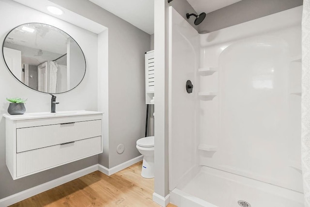 9811 Cambridge Ave, Kansas City, MO 64134 - full bath featuring wood finished floors, a shower with curtain, toilet, baseboards, and vanity