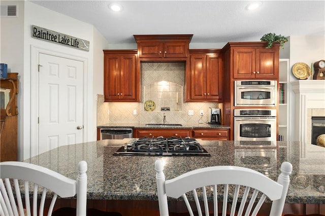 4704 SW Gull Point Dr, Lees Summit, MO 64082 - kitchen with stainless steel appliances, a kitchen bar, a sink, tasteful backsplash, and recessed lighting