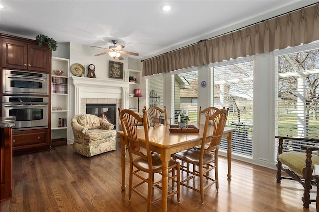 4704 SW Gull Point Dr, Lees Summit, MO 64082 - dining room featuring ceiling fan, a tiled fireplace, dark wood-style floors, and recessed lighting