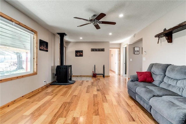 6721 S Read Rd Unit 1, Pleasanton, KS 66075 - living room featuring a wood stove, light wood-style floors, a ceiling fan, a textured ceiling, and recessed lighting