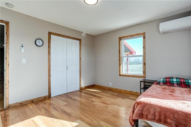 6721 S Read Rd Unit 1, Pleasanton, KS 66075 - bedroom with a wall mounted air conditioner, light wood-style flooring, and baseboards