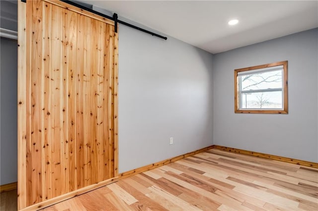 6721 S Read Rd Unit 1, Pleasanton, KS 66075 - empty room featuring wood finished floors, a barn door, recessed lighting, and baseboards