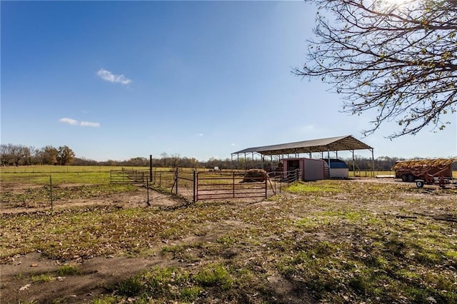 6721 S Read Rd Unit 1, Pleasanton, KS 66075 - view of yard featuring a view of countryside, an outbuilding, a detached carport, an exterior structure, and fence