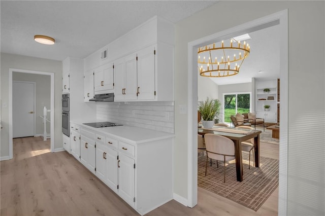 14 Woodbridge Ln, Kansas City, MO 64145 - kitchen with light wood-type flooring, white cabinetry, backsplash, light countertops, and a chandelier