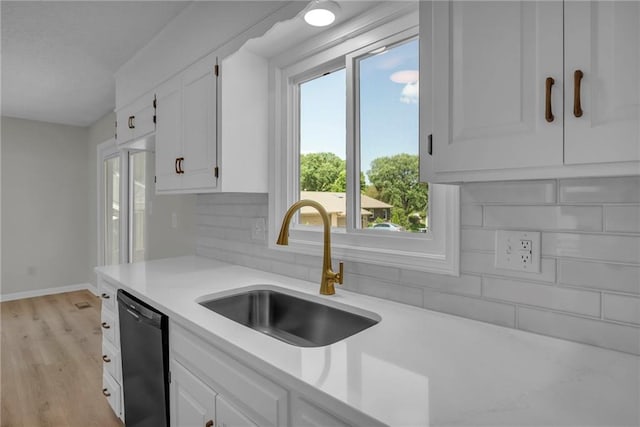 14 Woodbridge Ln, Kansas City, MO 64145 - kitchen featuring dishwasher, a sink, light countertops, and white cabinetry