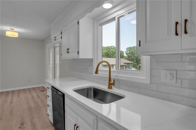 14 Woodbridge Ln, Kansas City, MO 64145 - kitchen with dishwasher, a sink, light countertops, backsplash, and white cabinetry